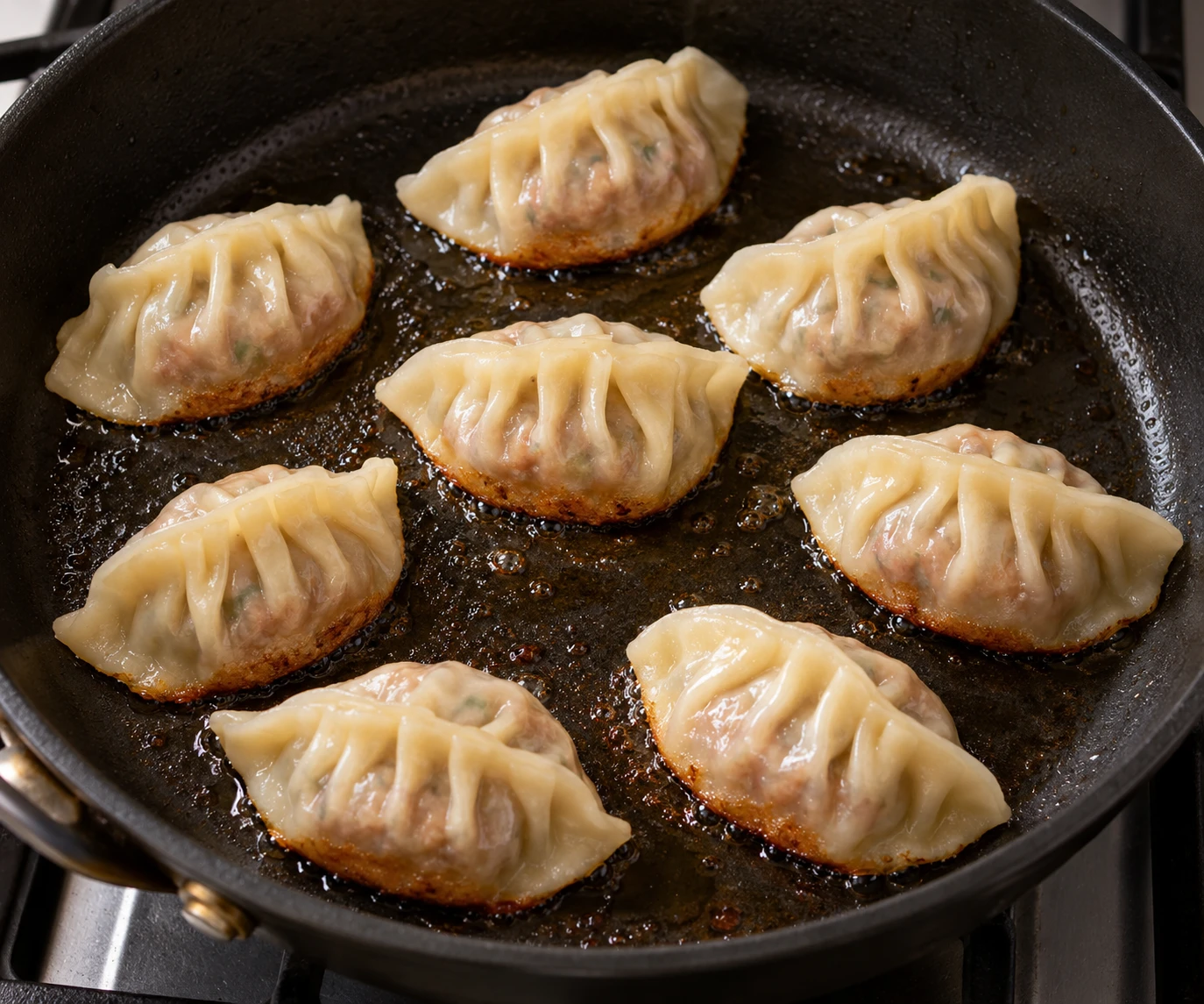 Pleated beef dumplings brown flat-side down in a lightly oiled skillet before steaming.