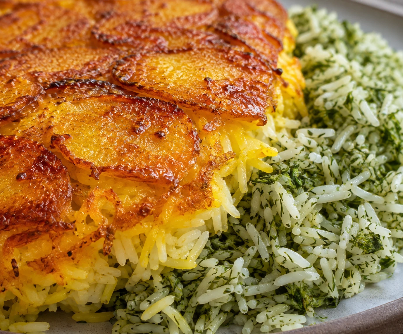 A crisp golden saffron potato crust rests beside separate grains of green herb rice.